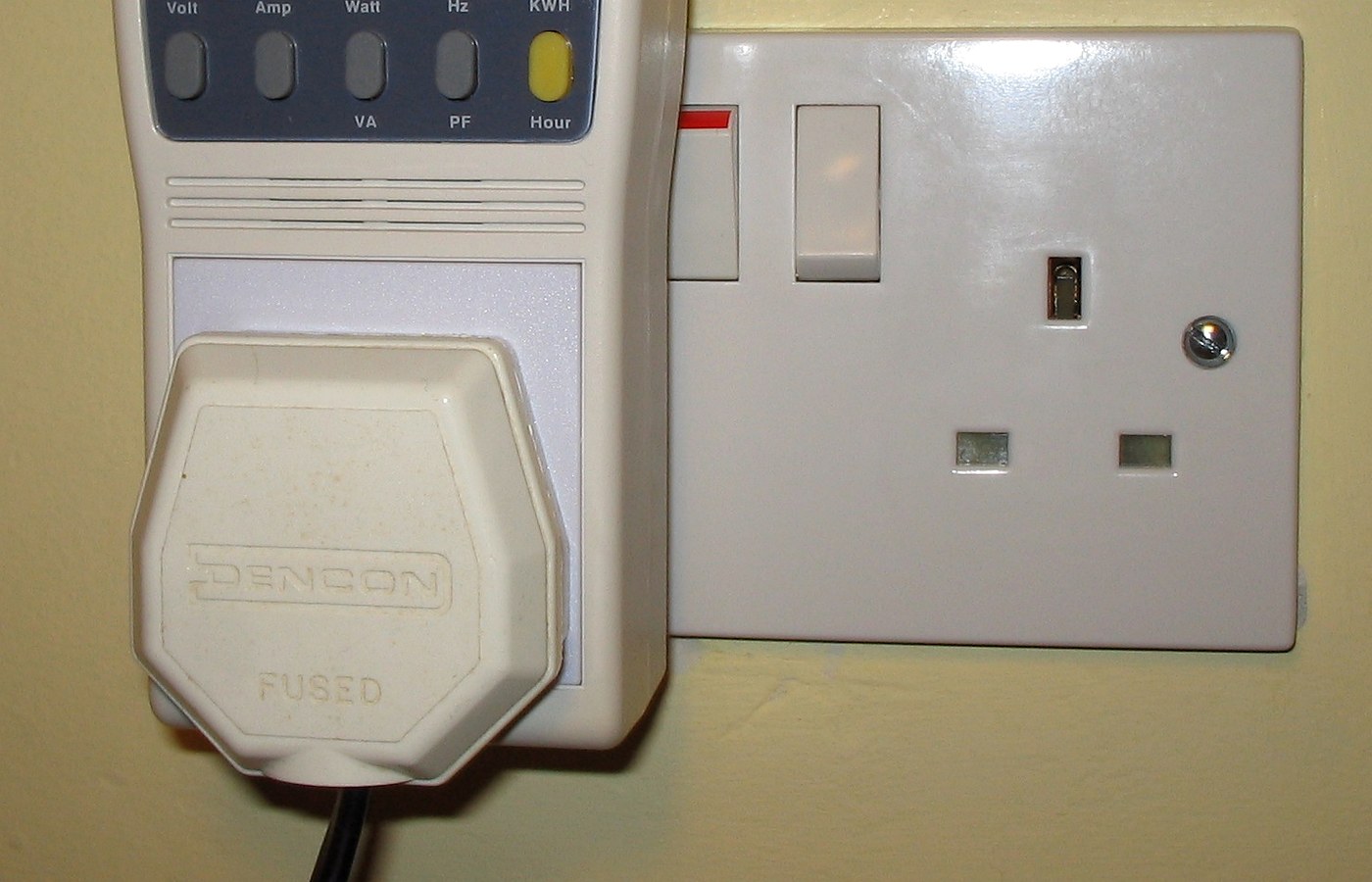 Real photo of plug-in power and energy monitor in uk domestic mains socket for How to read a plug monitor without overreacting to one number