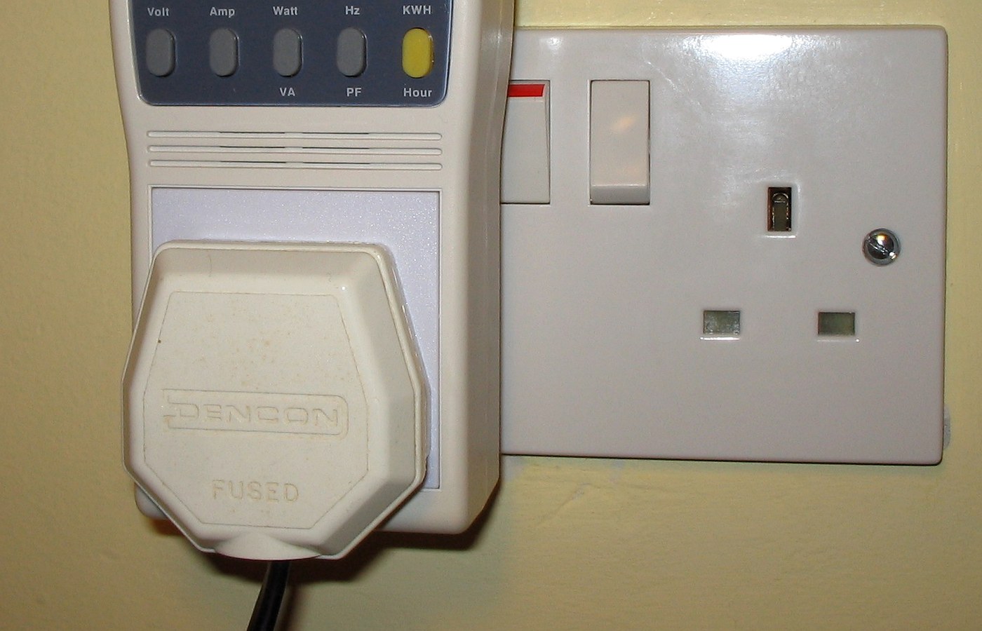 Real photo of plug-in power and energy monitor in uk domestic mains socket for Plug-in energy monitors: what they can and cannot tell you